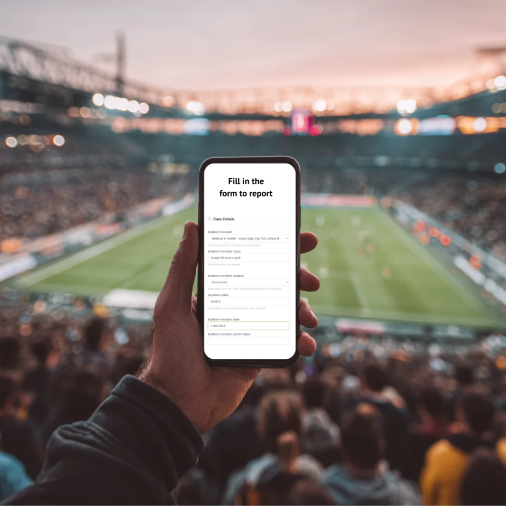 Fan holding a phone showing an incident report form in a football stadium