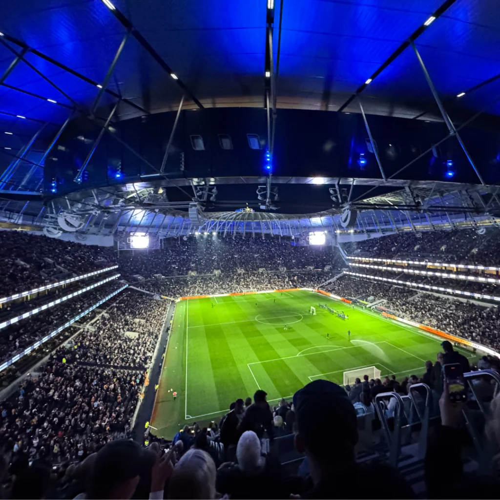 Packed football stadium under floodlights